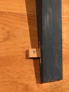 A wooden button used to attach a table top to a brace.